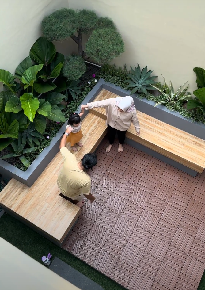 Ruang makan outdoor dengan meja panjang dan lampu gantung di atasnya